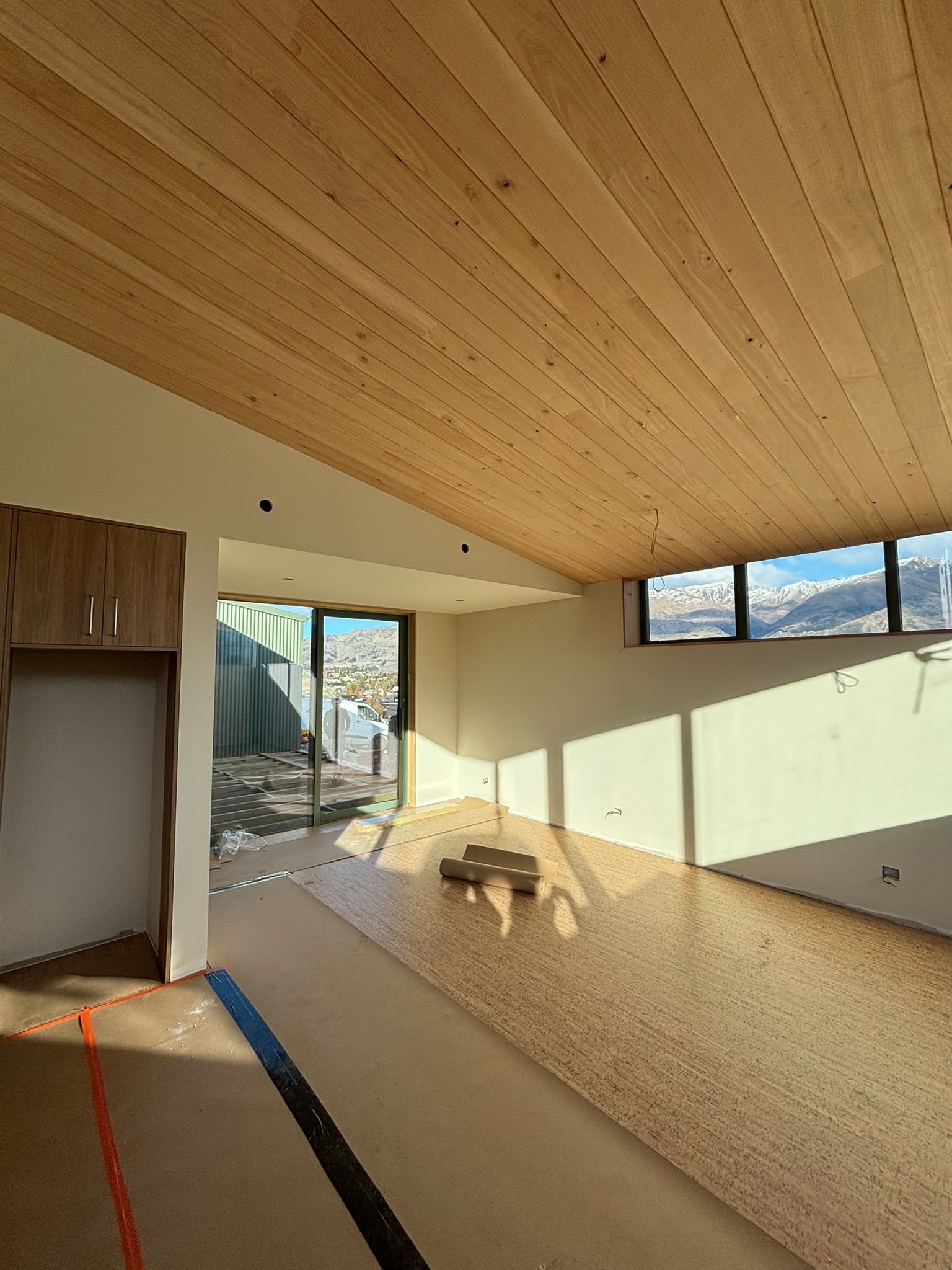 Living room under the macrocarpa ceiling, snow on the range