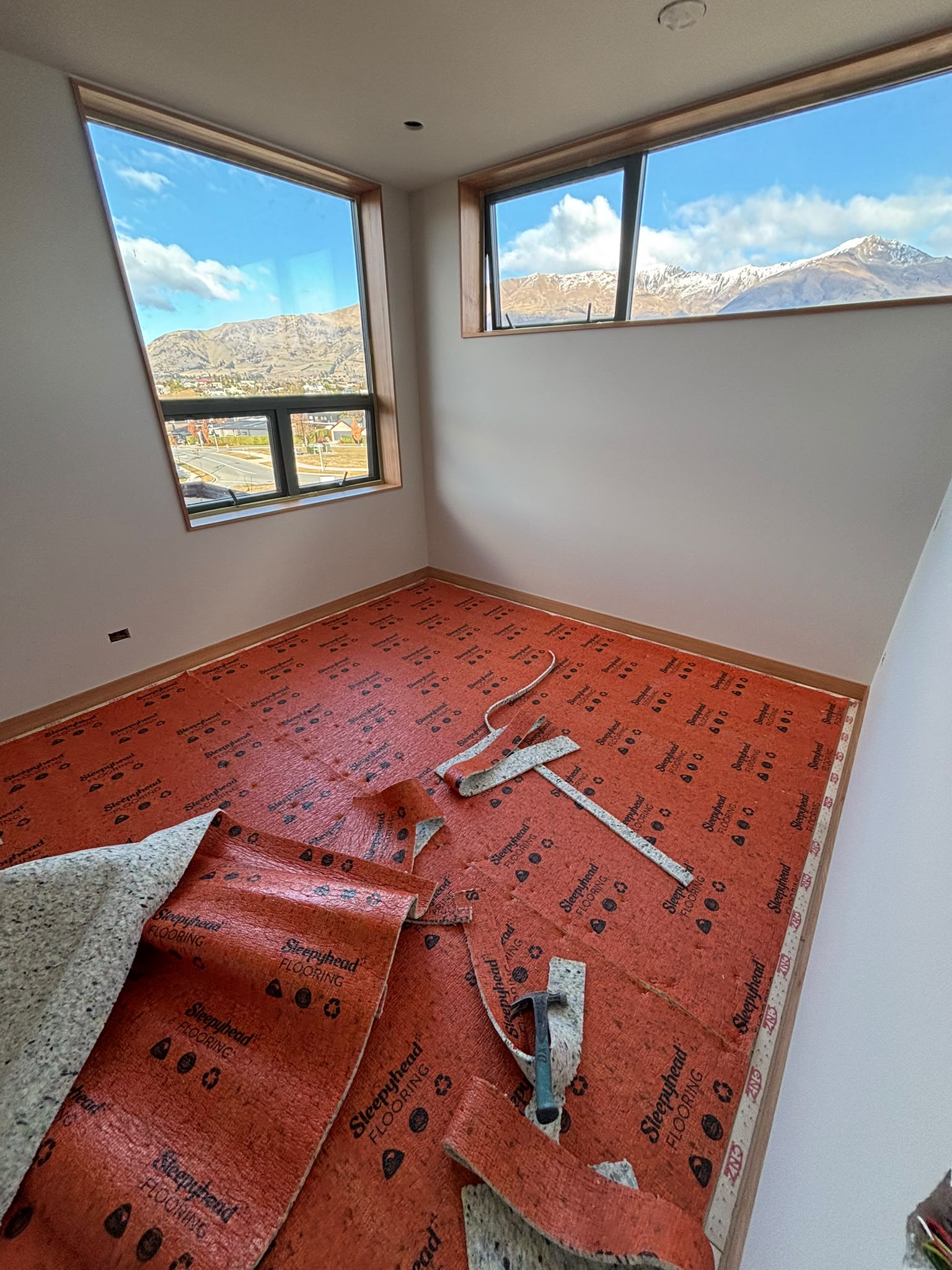 Corner windows in a bedroom, framing the snowline